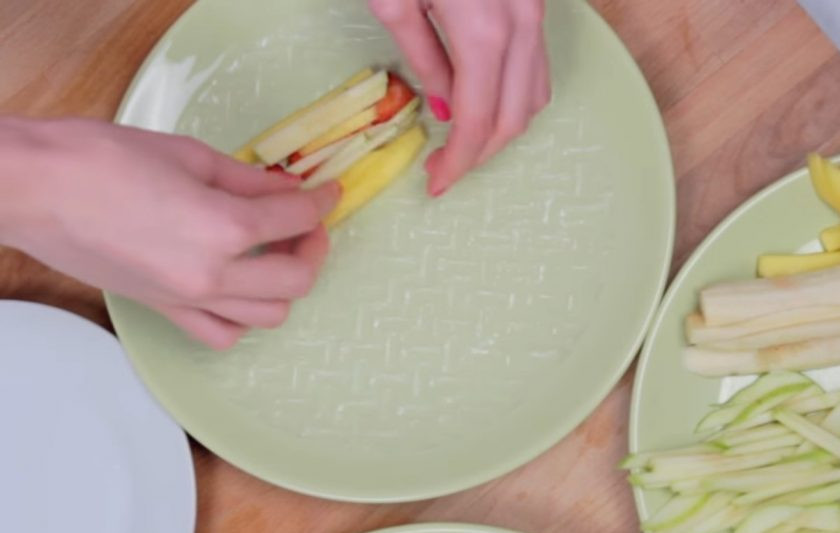 1. Этап. Фруктовые спринг-роллы: 2. Рисовую бумагу смочите в холодной воде с обеих сторон и выложите на нее начинку: сначала нарезанные ломтиками киви и клубнику, затем остальные фрукты.