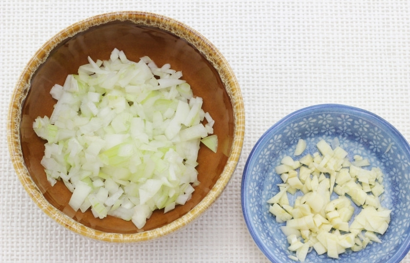 1. Этап. Жареный рис с курицей: Мелко нарубите репчатый лук и чеснок.