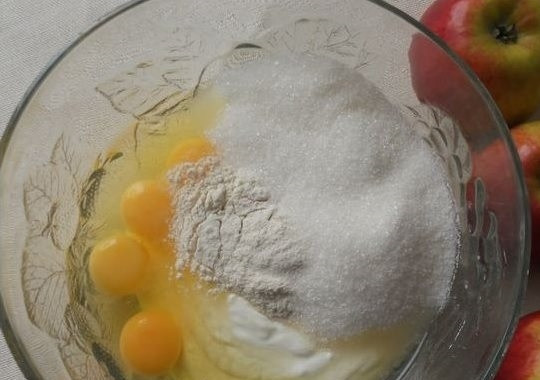 1. Этап. Цветаевский яблочный пирог в мультиварке: 2. Приготовьте заливку для пирога. В глубокой емкости соедините яйца, сахар, оставшуюся сметану и 2 ст. л. муки. При помощи миксера смешайте в однородную массу.