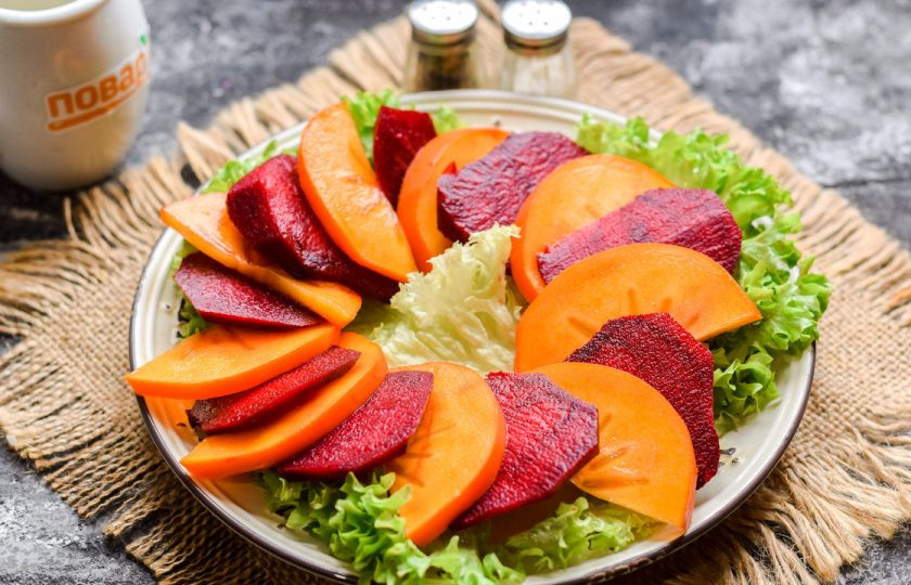 1. Этап. Салат с хурмой и свеклой: Вареную свеклу нарежьте пластинами, выложите по кругу свеклу и хурму, чередуя их, как показано на фото.