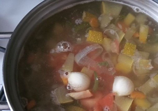 1. Этап. Новогодний минестроне: Выкладываем в кастрюлю кубики тыквы и цуккини. Варим ещё минут 10. Теперь очередь пасты, помидора, порезанного тоже мелким кубиком, и зубчиков чеснока. Варим минуты 3.