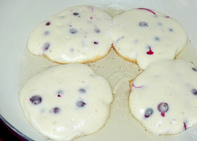 1. Этап. Бисквитные оладьи с черной смородиной: 5. Сковороду ставлю на огонь, наливаю в неё растительное масло, ложкой выкладываю небольшое количество теста.