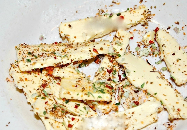 1. Этап. Запеченная индейка в рукаве целиком: 2. Сливочное масло разрежьте на небольшие кусочки, выложите в плошку. Добавьте специи и соль к сливочному маслу, чтобы кусочки масла были все в приправе.