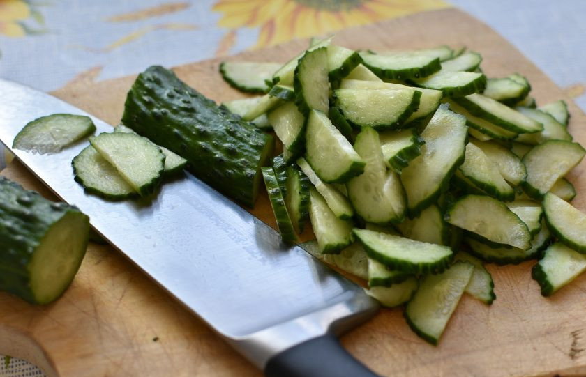 1. Этап. Освежающий салат из огурцов с арахисом: Продукты должны быть охлажденными, тогда салат будет вкуснее. Промытые и обсушенные огурцы разрежьте вдоль и нарежьте тонкими ломтиками. Выложите в просторную миску.