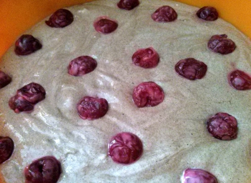 1. Этап. Бисквитный пирог с вишней: Выложите тесто в силиконовую форму (диаметр 22 см.), смоченную водой. Сверху разместите вишни без косточек, обваленные в крахмале.