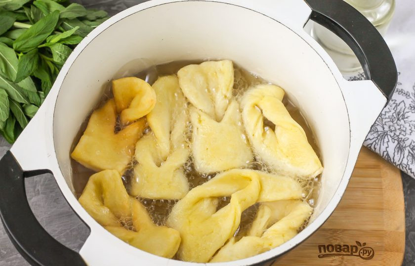 1. Этап. Хворост на коньяке: Разогрейте в казане или в ковше с антипригарным дном растительное масло без запаха и опустите в него 5-6 заготовок. Много не добавляйте, так как они вырастут в размерах. Обжаривайте примерно по минуте с каждой стороны до румяности. Помните, что масло должно быть практически кипящим, действуйте осторожно!