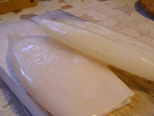 1. Этап. Кальмары, фаршированные рисом и овощами: 1. Кальмаров достаньте из морозилки заранее, когда они разморозятся, бросьте их в кипящую воду и проварите минут пять. Затем выньте из воды и оставьте остывать. С подостывших кальмаров снимите пленочки.