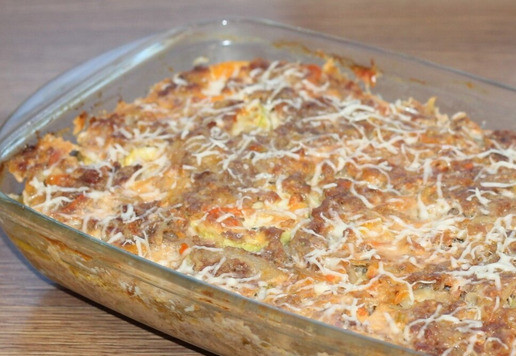 1. Этап. Запеканка с картофелем, кабачками, мясным фаршем: 16. Натрите сыр на крупной тёрке и посыпьте содержимое формы. Запекайте без фольги ещё 20 минут или до готовности запеканки.