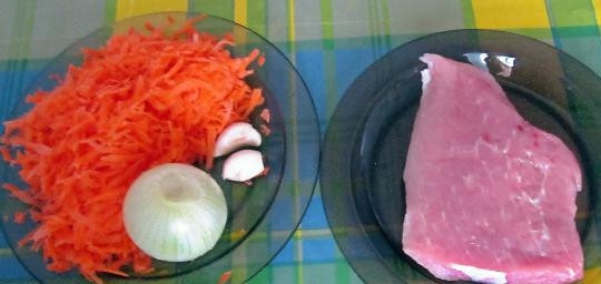 1. Этап. Свинина с рисом в горшочке: Подготавливаем необходимые продукты: лук и мясо нарезаем кубиками, чеснок пластинками, а морковь трем на крупной терке.