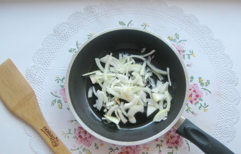 1. Этап. Салат с мясом и жареными шампиньонами: Репчатый лук очистите, помойте и нарежьте произвольно. Выложите в сковороду с рафинированным подсолнечным маслом.
