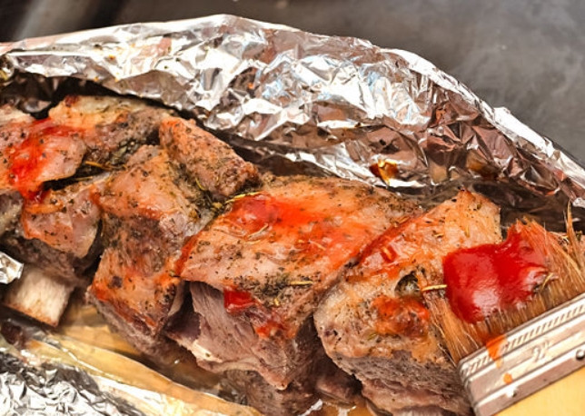 1. Этап. Говядина на кости: Для заключительного этапа нам потребуется приготовить соус. Смешайте в кастрюле полтора стакана неострого кетчупа, полстакана коричневого сахара, 3 зубчика измельченного чеснока, 3 столовых ложки яблочного уксуса, 3 столовых ложки Вустерширского соуса, чайную ложку черного молотого перца и половину чайной ложки соли. Доведите соус до кипения и варите на слабом огне, помешивая, до полного растворения сахара. Откройте фольгу на ребрах и обильно смажьте сверху получившимся соусом.