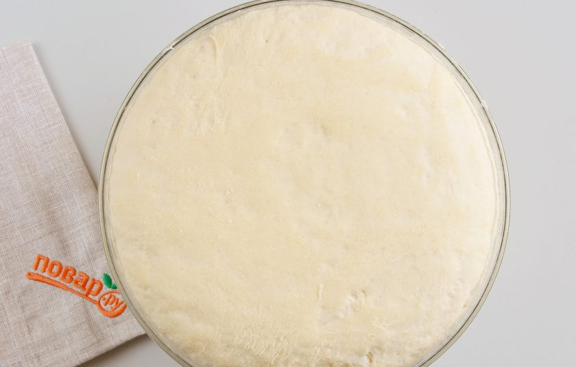 1. Этап. Пирог с картошкой: Спустя час тесто увеличится в 2-3 раза. Воздушное и легкое! Осадите его руками. Разделите на 2 части, одна чуть больше, другая меньшего размера.