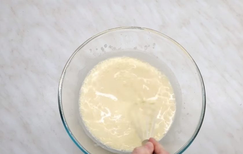 1. Этап. Пышные и мягкие оладушки: 2. Кислое молоко подсолите, добавьте желтки, перемешайте венчиком и добавьте соду. Далее добавьте просеянную через сито муку. Тесто должно получиться довольно густым.