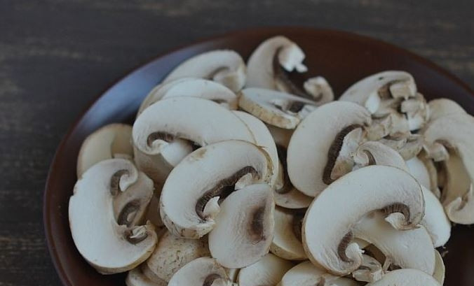 1. Этап. Салат с грибами и картофелем: Шампиньоны тщательно вымойте, почистите от песка и обсушите. Затем нарежьте грибы тонкими пластинками.