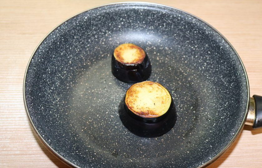 1. Этап. Порционный салат на Новый год: Обжаривайте баклажаны на разогретом масле с двух сторон до готовности.