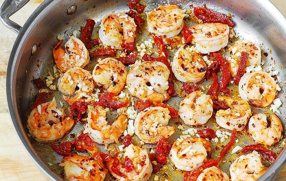 1. Этап. Спагетти с вялеными томатами: Далее в сковороду добавьте нарезанные томаты, ещё масло и измельчённый чеснок. Перемешайте и обжарьте ингредиенты 1 минуту. В это же время отварите спагетти аль денте.