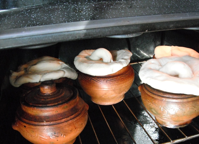 1. Этап. Курица с грибами в горшочке: Спустя это время содержимое горшочков нужно проверить на готовность и, при желании, заменить керамические крышки на съедобные, после чего запекать еще 15-20 минут - до готовности теста.