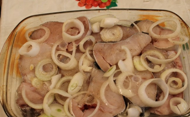 1. Этап. Филе трески в духовке под сыром: Лук порежьте кольцами. В форму для выпекания сначала положите лучок одним слоем, потом рыбу, потом сверху опять лучок.