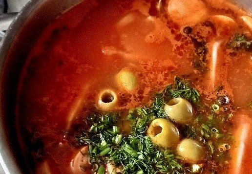 1. Этап. Солянка День 1 января: Теперь выкладываем перцы, лавровый лист. Варим 3 минуты. Добавляем укроп, помидор и оливки. Перемешиваем, солим по вкусу. Варим ещё 2 минуты. Помидор останется целыми дольками, в нём сохранятся все витамины. Снимаем с огня. Пусть солянка остынет. Поставим её в холодильник до того времени, пока мы не проснёмся 1 января.