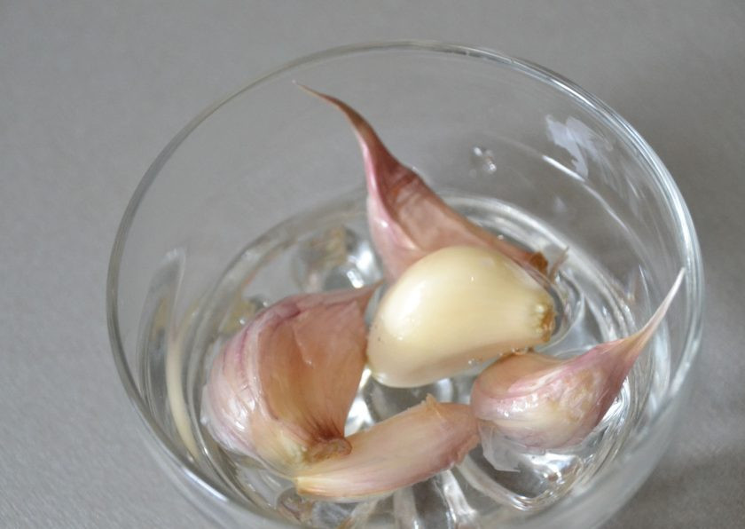 1. Этап. Кальмары в чесночном соусе: Извлеките чеснок из кипятка и поместите его в холодную воду.