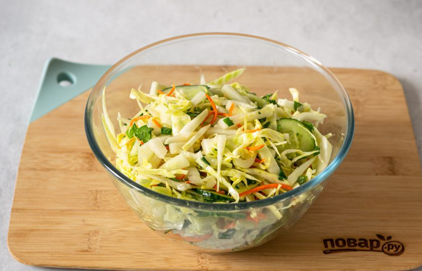 1. Этап. Салат с огурцом и капустой кольраби: Соедините все ингредиенты в глубокой миске, добавьте мелко порубленную зелень и тонко натертую морковь. Влейте заправку и перемешайте.