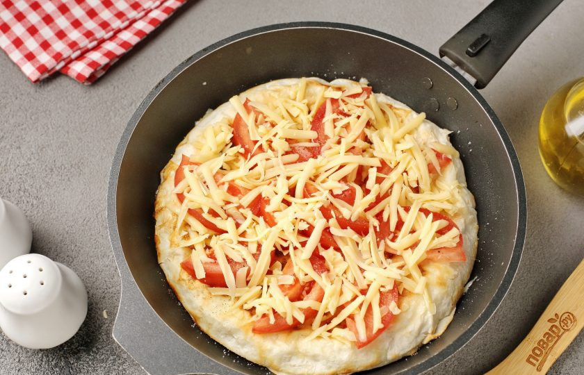 1. Этап. Яичница с помидором и сыром в лаваше на сковороде: Посыпьте помидоры оставшимся тёртым сыром. Накройте крышкой и готовьте ещё около 8 минут или пока сыр не расплавится.