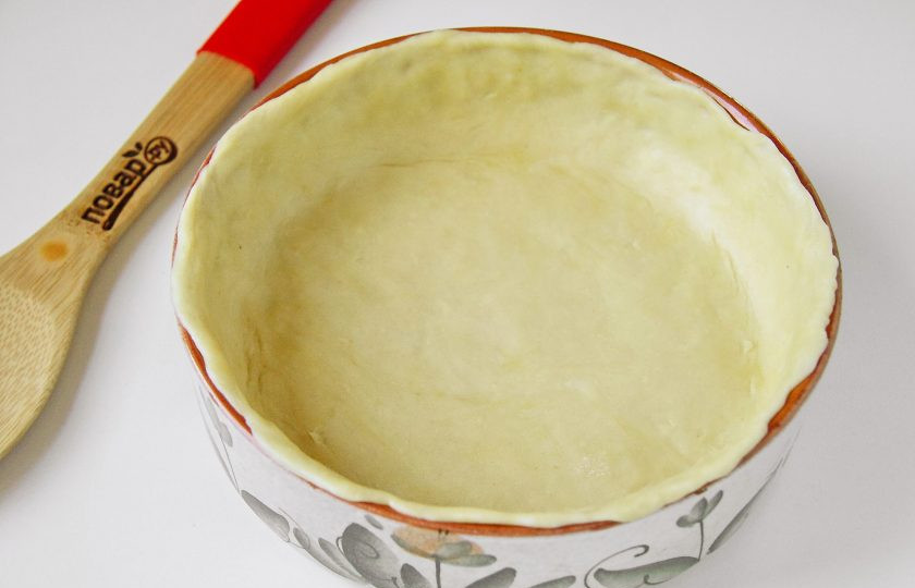 1. Этап. Мясной пай: Тесто разделите на две неравные части. Большую часть теста раскатайте по размеру формы, перенесите его в нее и руками сформируйте высокие бортики. Форму для выпечки предварительно смажьте маслом.