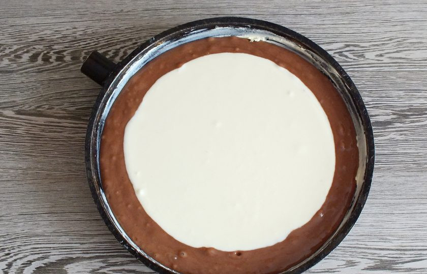 1. Этап. Шоколадная ватрушка с творогом: Визуально определите середину в сковороде с тестом. По ложке, выкладывайте в середину творожную начинку. Не торопитесь, дожидайтесь пока порция начинки распределится. Это необходимо, чтобы начинка равномерно легла на тесто. Подготовленную ватрушку поставьте выпекаться в разогретую духовку на 35-40 минут.