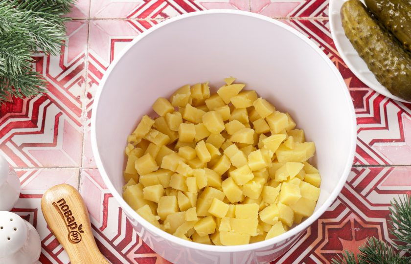 1. Этап. Салат Оливье на год Змеи: Картофель очистите и нарежьте мелкими кубиками.