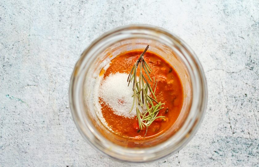 1. Этап. Самогон на облепихе: Добавьте к облепихе сахар и веточку розмарина.