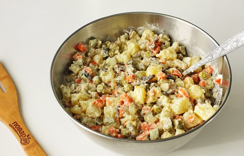 1. Этап. Постный Оливье с грибами: Заправьте салат постным майонезом, посолите и поперчите по вкусу, после чего хорошо перемешайте.