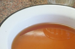 1. Этап. Карамельный медовик постный: Теплую, даже горячую, воду постепенно добавляйте к карамели. Она вначале начинает бурно кипеть, но не пугайтесь, а решительно и осторожно выливайте всю воду, продолжая помешивать, пока карамель не растворится. Получившуюся сладкую воду перелейте в миску и вынесите на холод остывать.