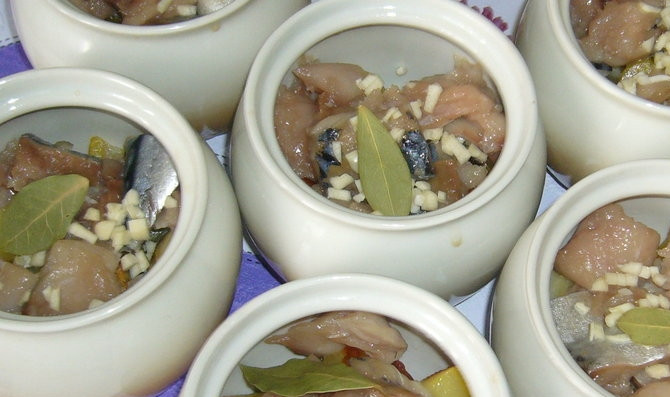 1. Этап. Скумбрия в горшочке: В горшочки слоями выкладываем картофель, затем рыбу, лавровый лист и выдавливаем чеснок.