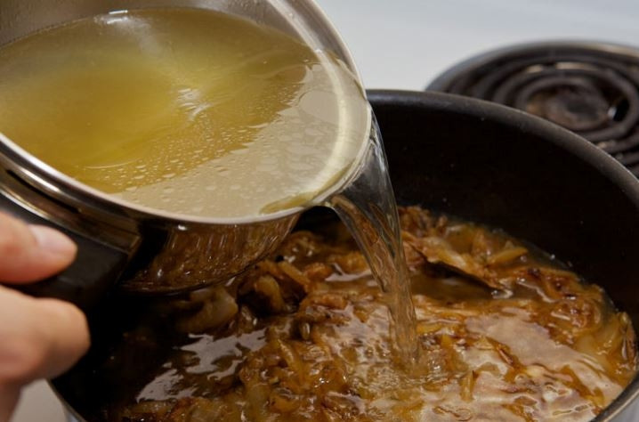 1. Этап. Классический луковый суп: 4. Залейте лук бульоном, добавьте соль по вкусу, смешайте все и доведите до кипения. Затем накройте крышкой и уменьшите тепло, держите 30-40 минут.