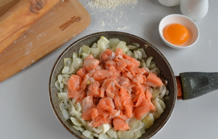 1. Этап. Слоеный пирог с семгой: Семгу порежьте небольшими кусочками, добавьте её к луку и обжарьте до изменения цвета рыбы. Добавьте в процессе пару щепоток соли.