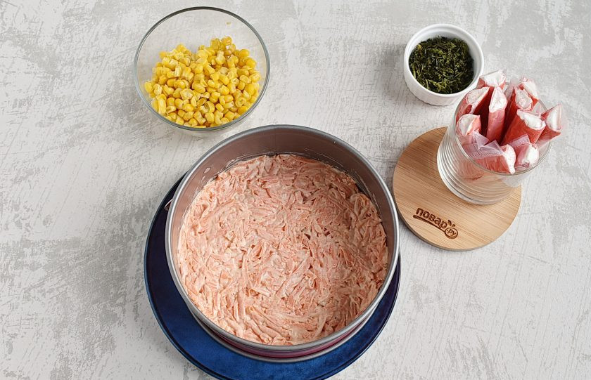 1. Этап. Крабовый салат с рисом и кукурузой: Сверху выложите морковь с майонезом.