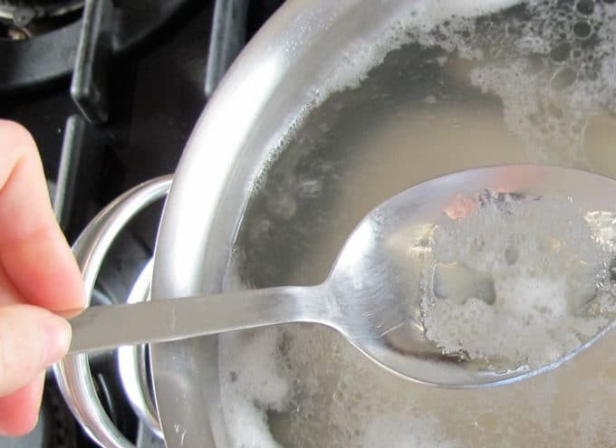 1. Этап. Суп с курицей на гриле: 2. Затем залейте куриные кости с кожей и жиром 2 литрами воды. Доведите бульон до кипения, снимая пенку. Добавьте перец, измельчённый чеснок (2 зубчика), сельдерей (2 шт) и одну нарезанную морковь. Также всыпьте соль, измельченную петрушку и лавровый лист. Положите целую очищенную луковицу.