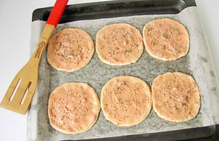 1. Этап. Мини пицца: Смажьте тесто соусом и посыпьте ароматными травами.