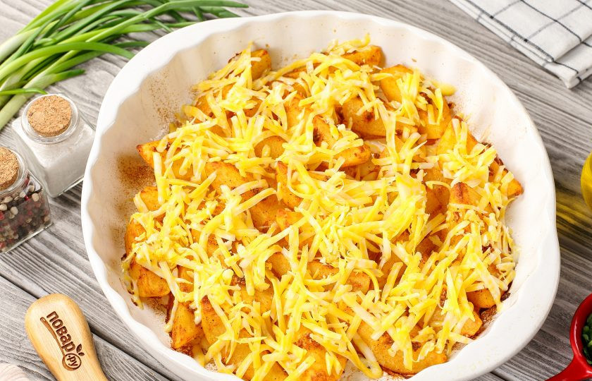 1. Этап. Картофельные дольки с сыром в духовке: За 5-10 минут достаньте картошку и посыпьте тёртым сыром.