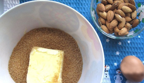 1. Этап. Рождественское печенье со специями: В миску с высокими бортиками насыпьте коричневый сахар и положите размягченное сливочное масло. Взбивайте ингредиенты миксером, в процессе добавляя темный мед и сырое куриное яйцо.