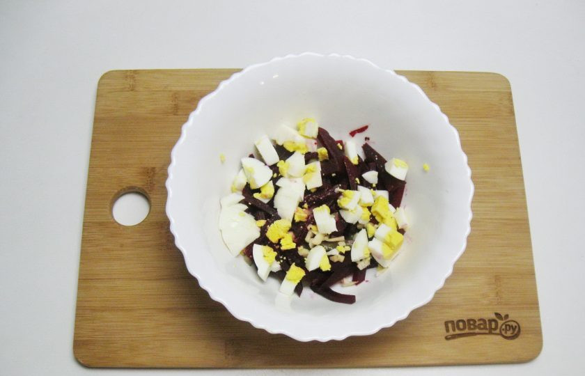 1. Этап. Салат с кальмарами и свеклой: Яйца сварите вкрутую, охладите, очистите и мелко нарежьте. Выложите в салат.