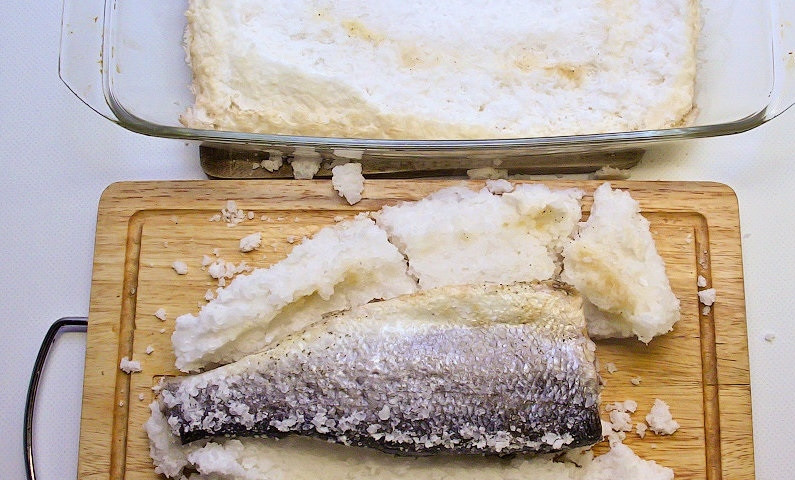 1. Этап. Сибас в соли: 7. Достаю форму из духовки, ложкой стучу по соляному панцирю, чтобы он отошел от рыбы, после этого перекладываю рыбу на разделочную доску.