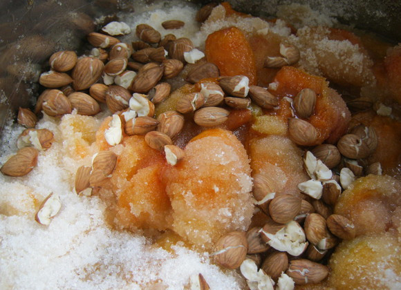 1. Этап. Варенье из абрикосов без воды: Затем выкладываем половинки абрикосов в глубокую кастрюлю или таз, добавляем ядрышки и засыпаем все сахаром. Накрываем посуду полотенцем и оставляем абрикосы так до тех пор, пока они не пустят достаточно сока и пока сахар не растворится.