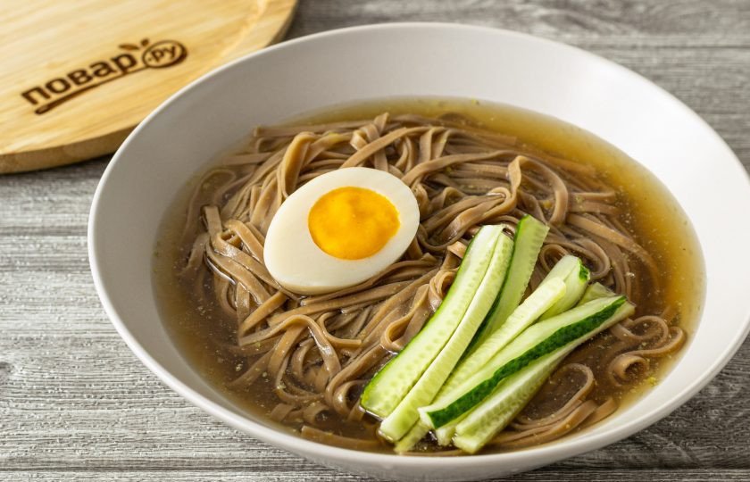 1. Этап. Лапша Нэнмён: Влейте холодный бульон. Добавьте яйцо и огурец.