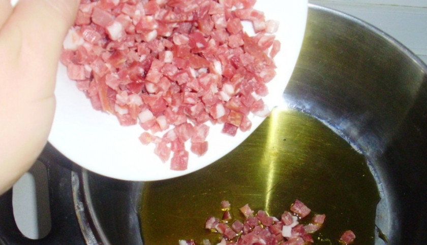 1. Этап. Суп с белой фасолью консервированной: В кастрюле с толстым дном разогрейте масло. Слегка обжарьте в нём грудинку, которую предварительно нарежьте кубиками.