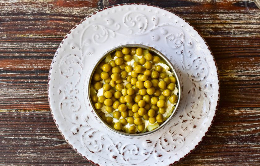 1. Этап. Оливье с ананасом: На картофель выложите консервированный горошек.