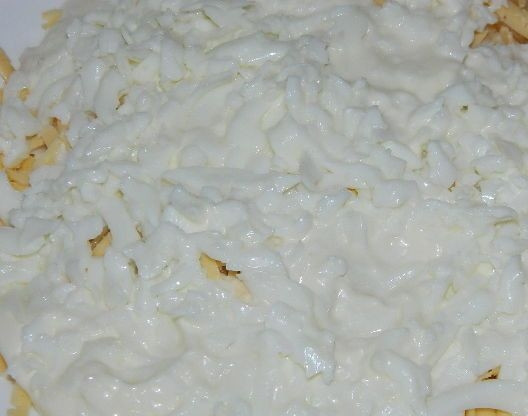 1. Этап. Салат с курицей и сыром: 5. Отделите белок от желтка и натрите яйца. Посыпьте третьим слоем белок и промажьте майонезом.