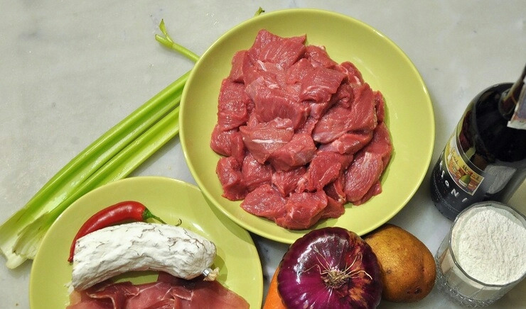 1. Этап. Говядина в чугунке в духовке: Подготовьте все необходимые ингредиенты. Мясо порежьте на небольшие кусочки. Морковку и лук порежьте крупно. Перец острый очистите от семян и порежьте соломкой. Картошку порежьте четвертинками. У помидоров удалите семена, порежьте овощи четвертинками.