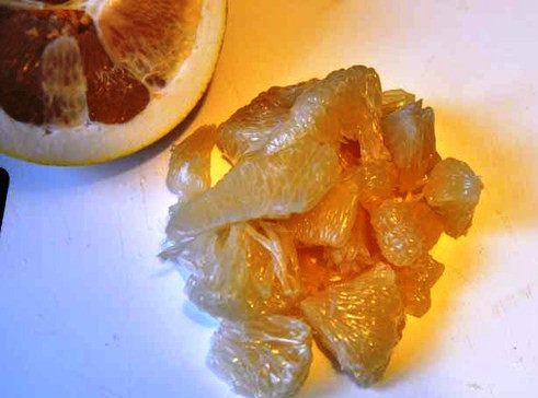 1. Этап. Салат с копчеными мидиями: Помело очистите и разделите на дольки.