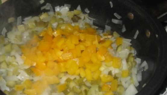 1. Этап. Солянка в горшочках: Лук очищаем и измельчаем. Обжариваем до мягкости в сотейнике. Затем добавляем мелко порезанные огурцы и перец, готовим еще несколько минут.